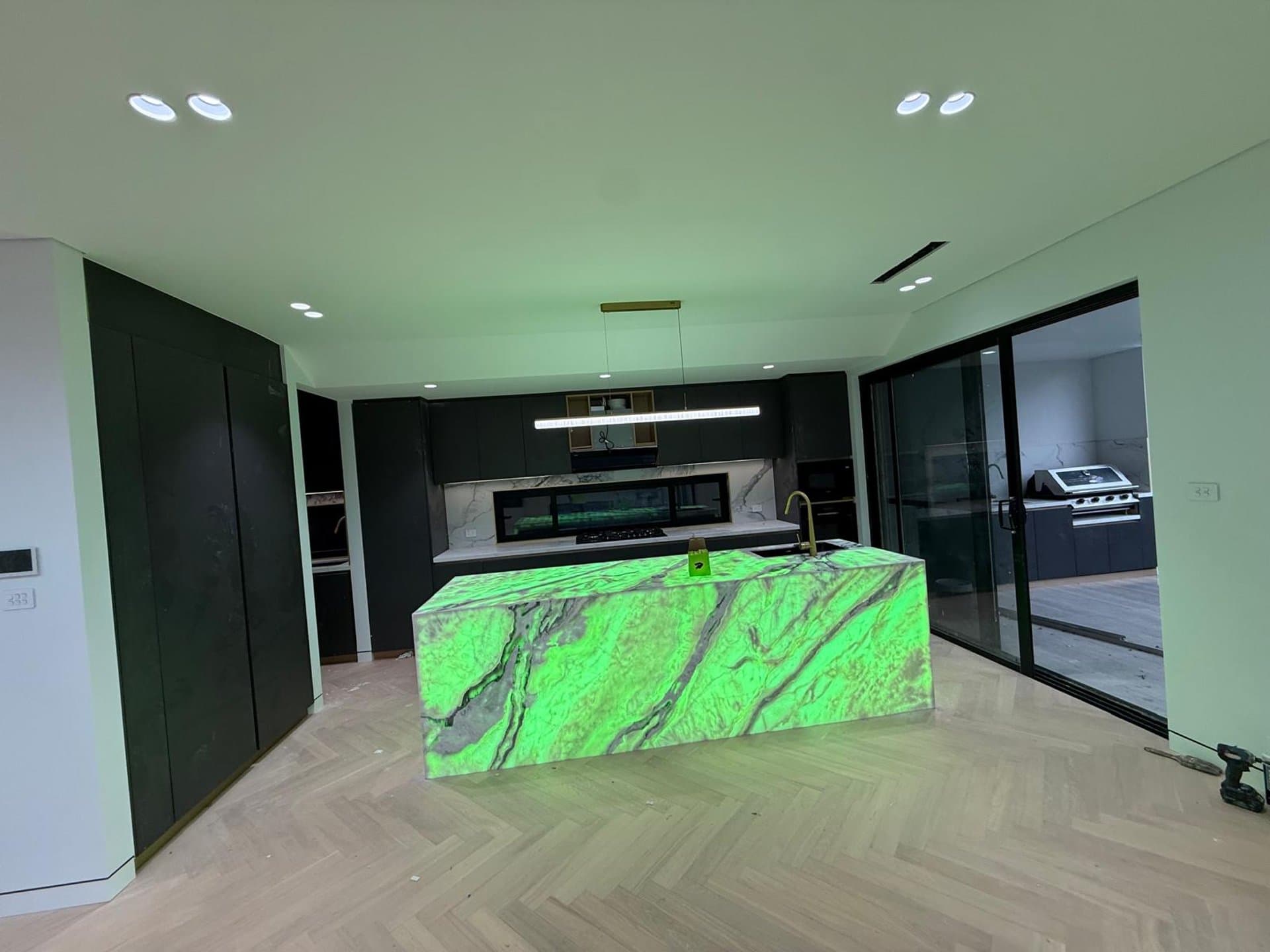 Sydney kitchen with a green marble island and dark cabinetry